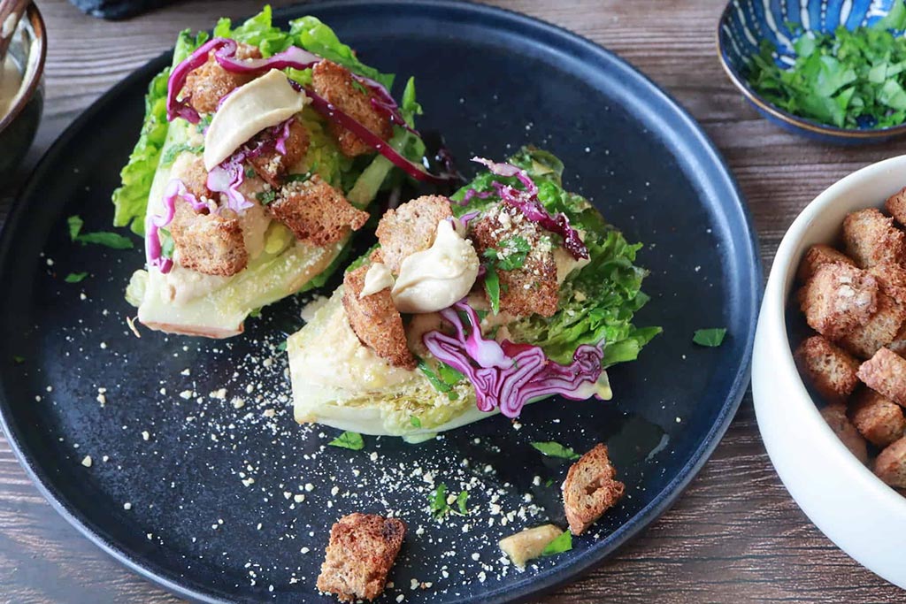 Insalata croccante con crostini di pane e dressing al formaggio vegano